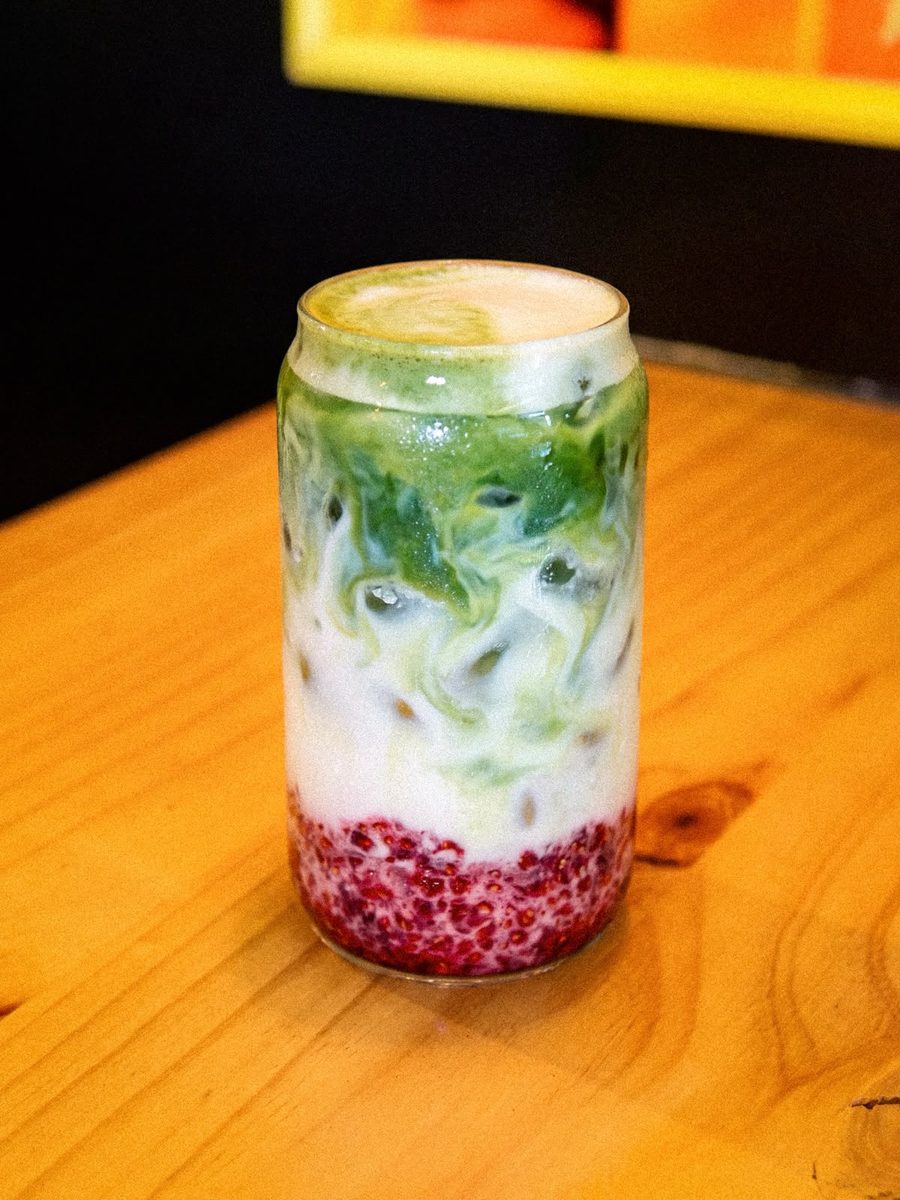 Matcha latte frío con frutos rojos en el fondo del vaso